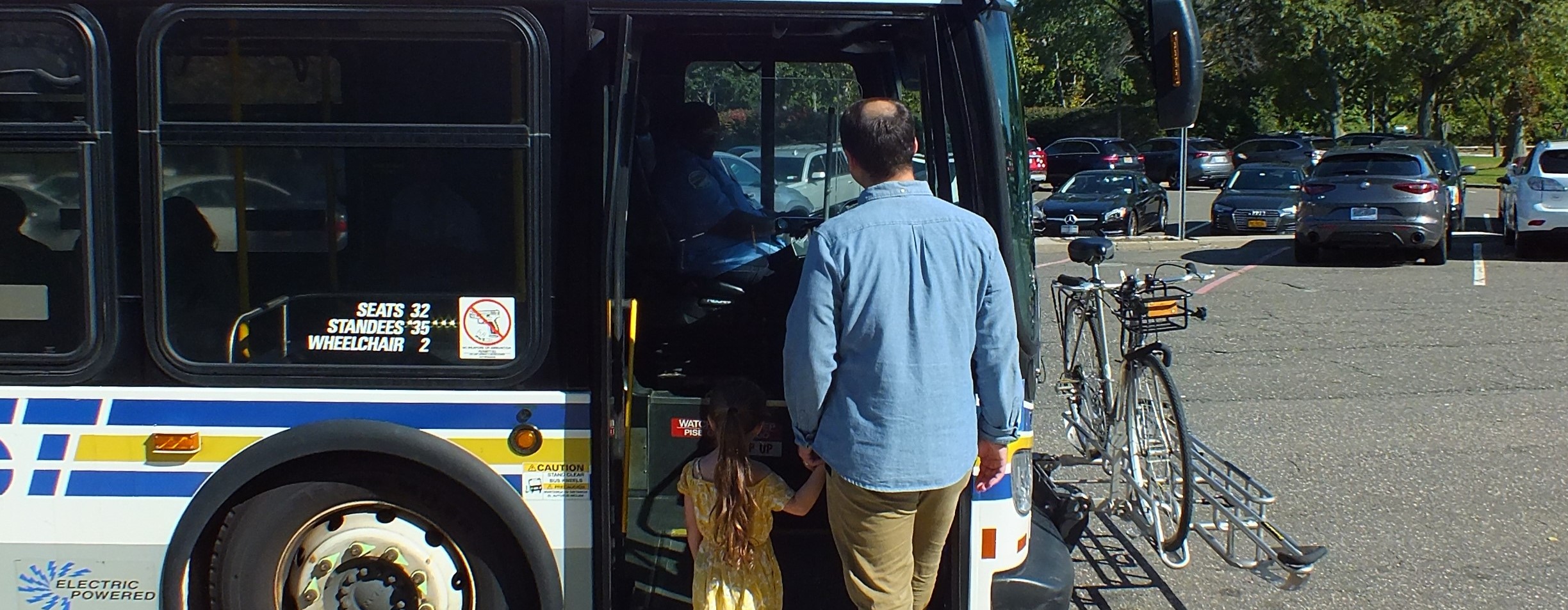 a man and his daughter getting onto a bus